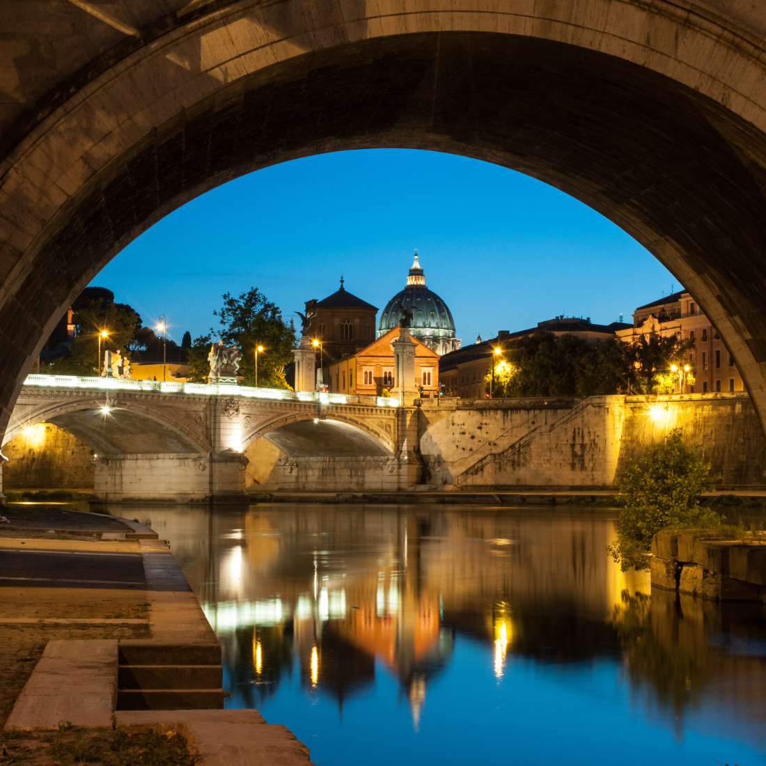 Tevere with the Vatican dome in the background at night.