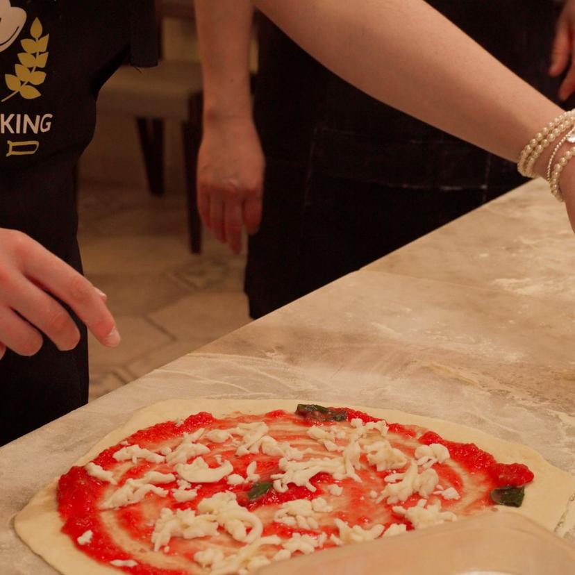 Tourist topping a pizza during the Pizza Masterclass in Rome