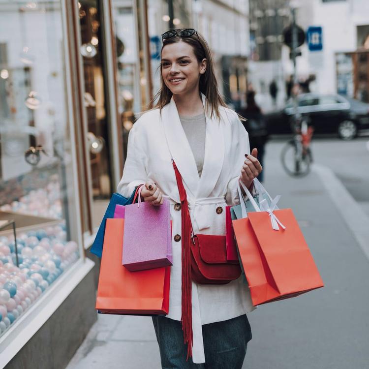 Young woman walking along Via del Corso in Rome after shopping with boutique bags
