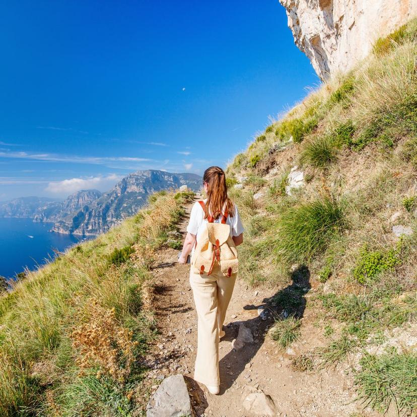 Girl walking on path ocean view Amalfi coast