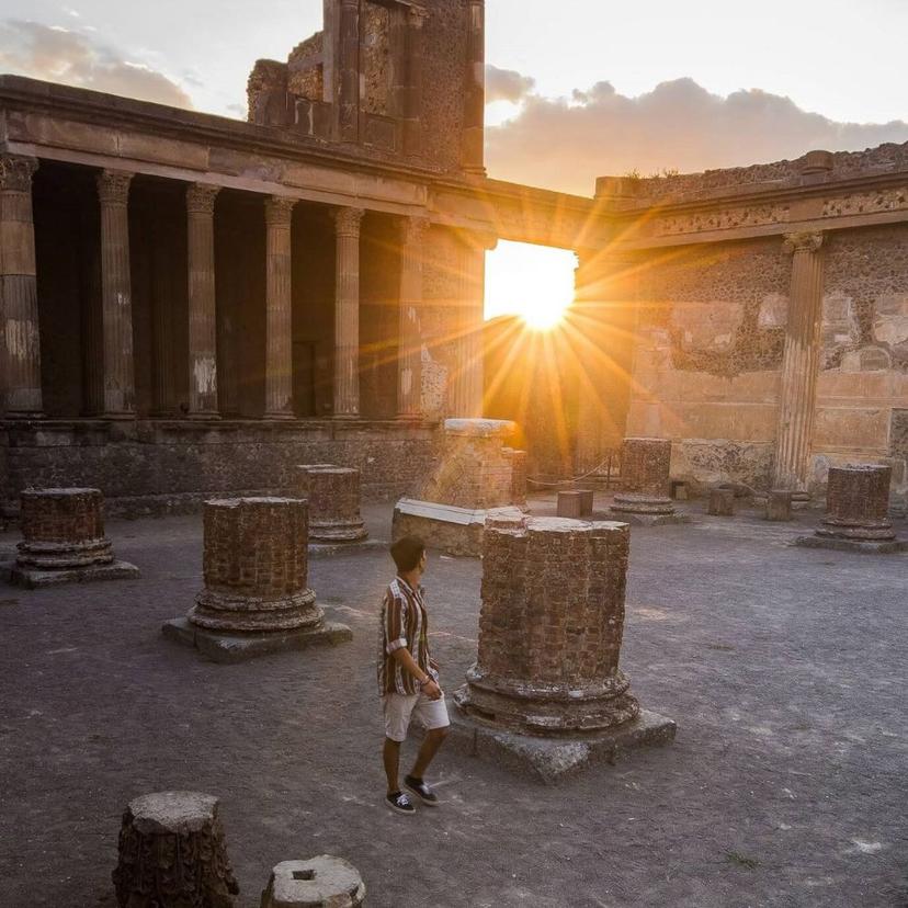 Pompeii tour man walking in shining sun next to old columns