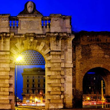 Monumental gate of the Aurelian Walls in Rome illuminated at night in Porta San Giovanni