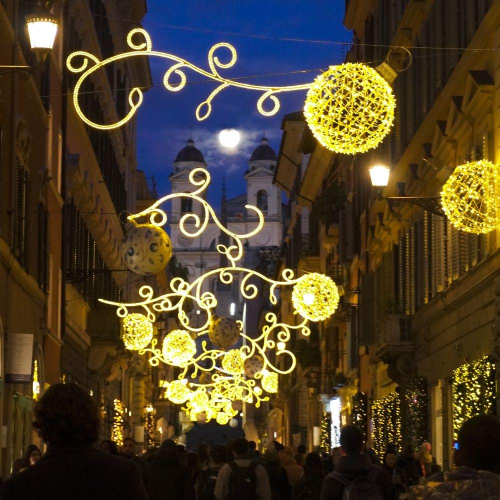 Rome at Christmas with festive lights illuminating a historic street at night