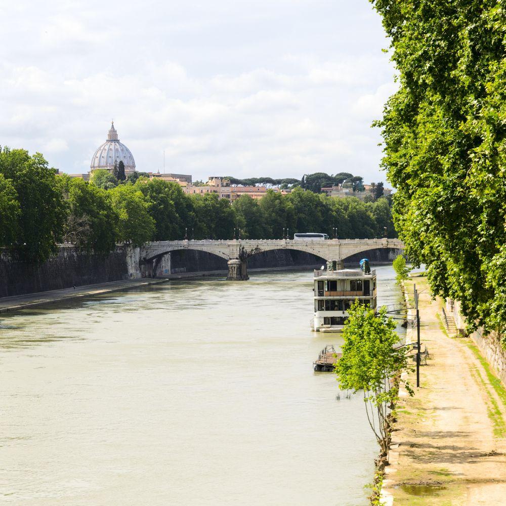 Panoramic view of the Tiber River in Rome with bridges, greenery, and city skyline