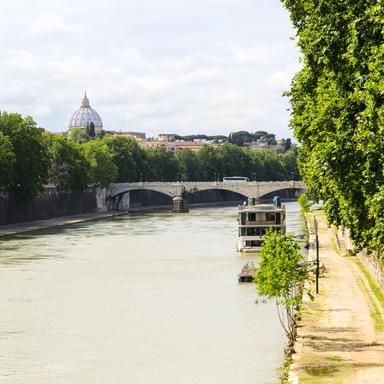 Panoramic view of the Tiber River in Rome with bridges, greenery, and city skyline