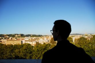 Traveller looking out over Rome and the Vatican from the Orange Garden on the Aventine Hill