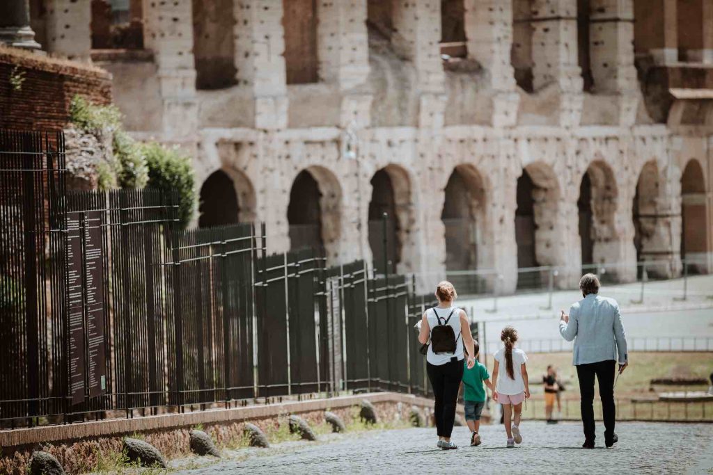 Family on a tour walking down the Via Sacra towards the Colosseum