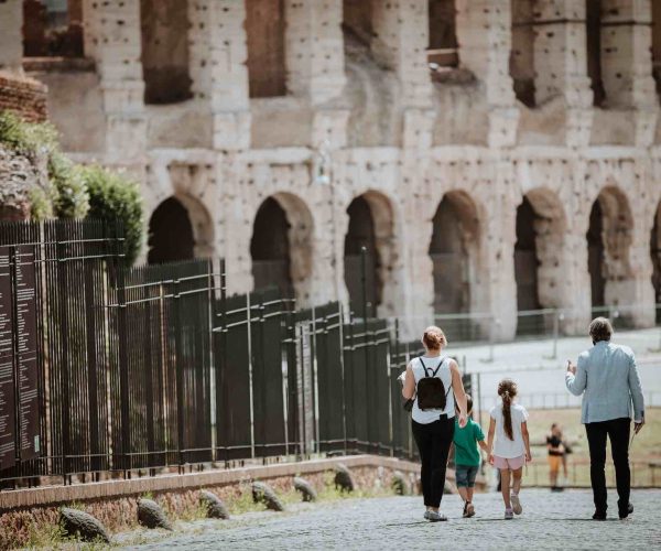 Famiglia in tour percorrendo la Via Sacra verso il Colosseo