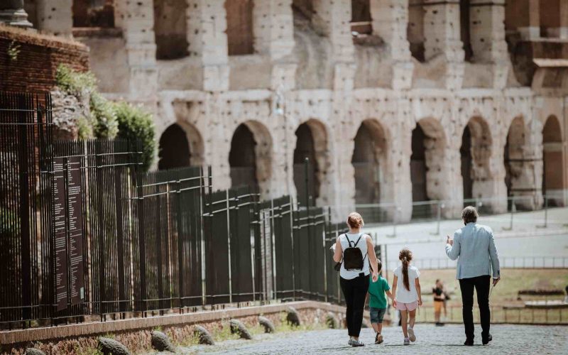 Family on a tour walking down the Via Sacra towards the Colosseum