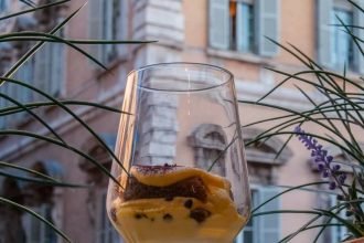 Tiramisù in a glass cup against Palazzo Madama in Rome's historic centre