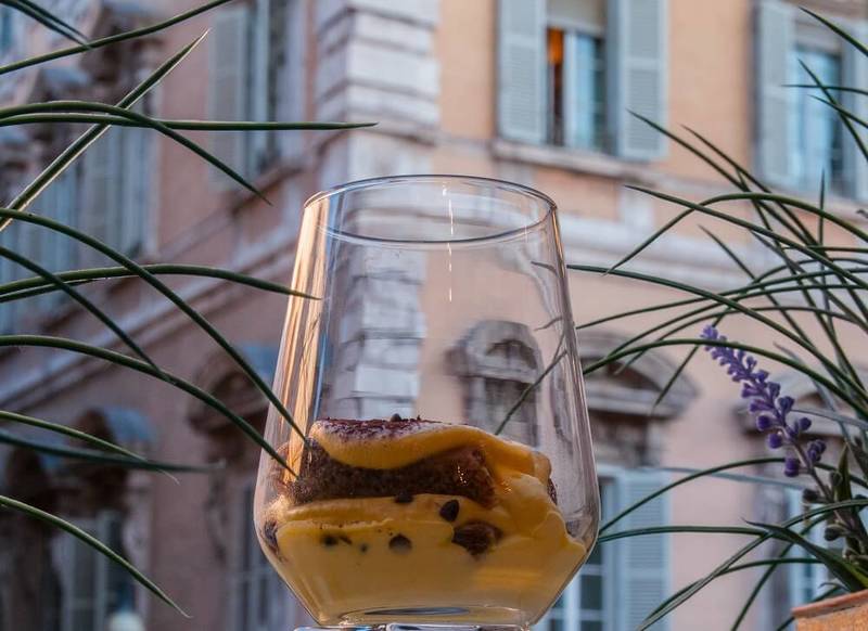 Tiramisù in a glass cup against Palazzo Madama in Rome's historic centre
