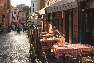 Un ristorante in una strada acciottolata di Roma nel quartiere di Trastevere